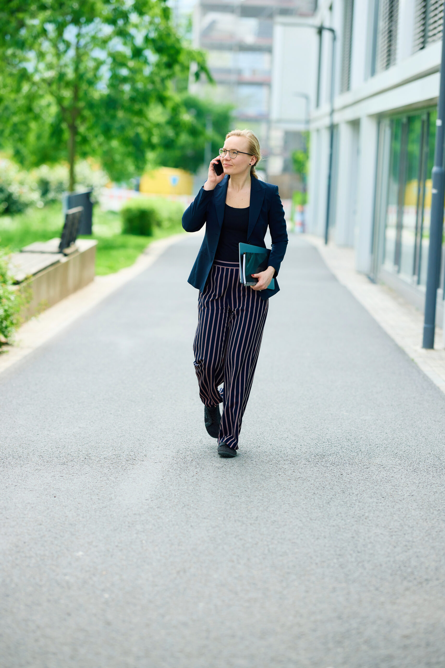 Mareike Walther telefonierend und auf die Kamera zulaufend im Ganzkörperbild