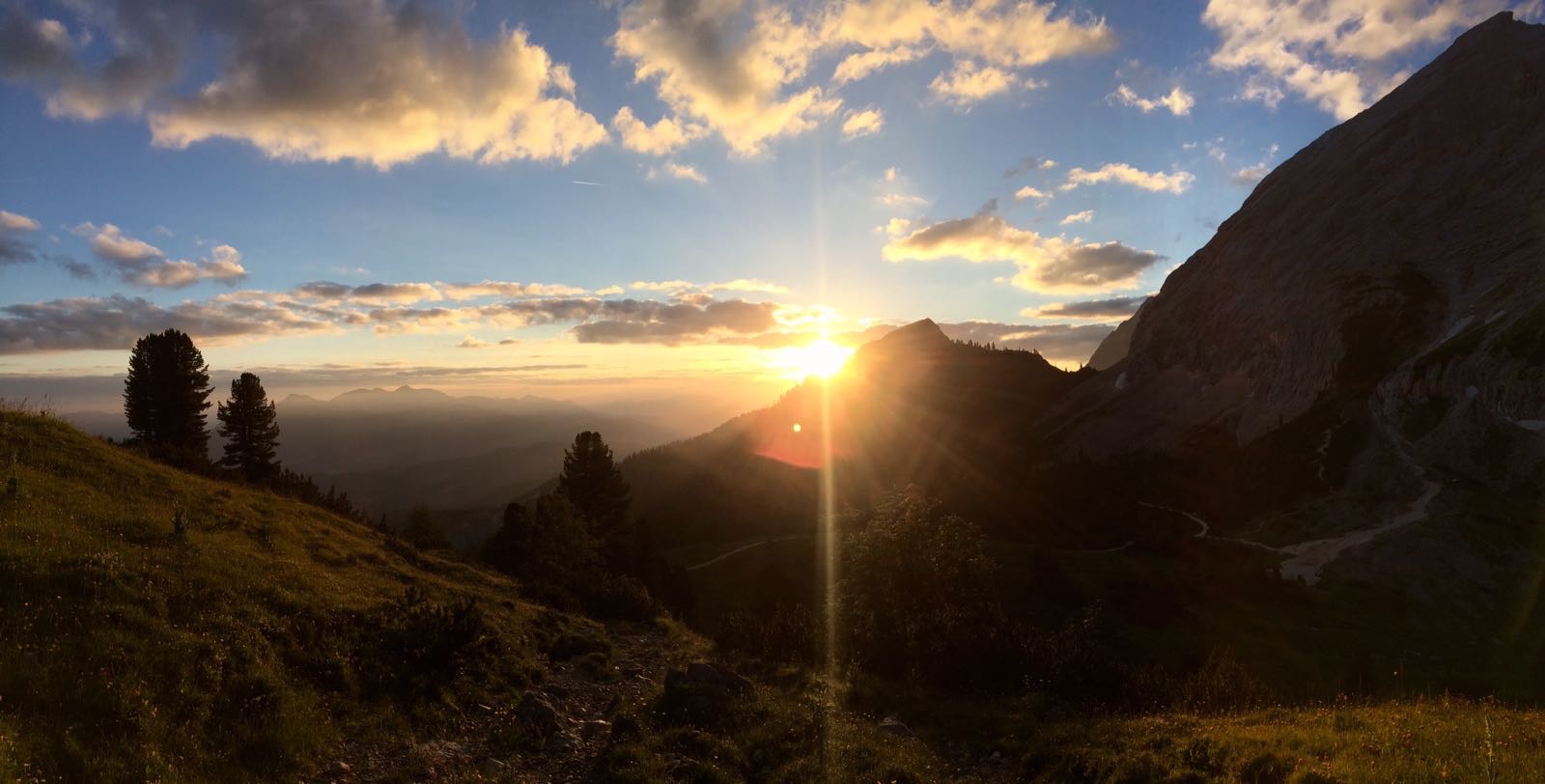 Sonnenaufgang über Bergen mit sanften Wolken am Himmel